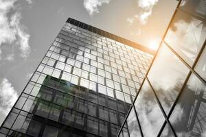 Modern architectural details. Modern glass facade with a geometric pattern. Contemporary corporate business architecture. Red sun on horizon. Black and white toned image. photo