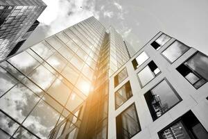 Modern architectural details. Modern glass facade with a geometric pattern. Contemporary corporate business architecture. Red sun on horizon. Black and white toned image. photo