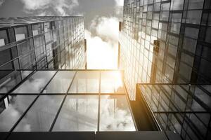 Modern architectural details. Modern glass facade with a geometric pattern. Contemporary corporate business architecture. Red sun on horizon. Black and white toned image. photo