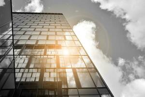 Modern architectural details. Modern glass facade with a geometric pattern. Contemporary corporate business architecture. Red sun on horizon. Black and white toned image. photo
