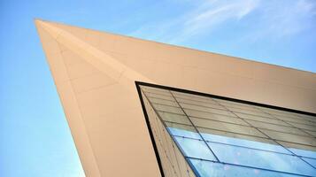 Glass building with transparent facade of the building and blue sky. Structural glass wall reflecting blue sky. Abstract modern architecture fragment. Contemporary architectural background. photo