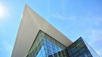 Glass building with transparent facade of the building and blue sky. Structural glass wall reflecting blue sky. Abstract modern architecture fragment. Contemporary architectural background. photo