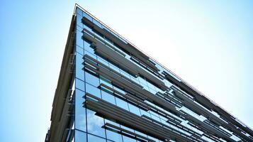 Glass building with transparent facade of the building and blue sky. Structural glass wall reflecting blue sky. Abstract modern architecture fragment. Contemporary architectural background. photo