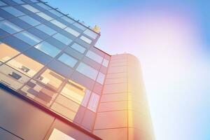 Glass building with transparent facade of the building and blue sky. Structural glass wall reflecting blue sky. Abstract modern architecture fragment. Contemporary architectural background. photo