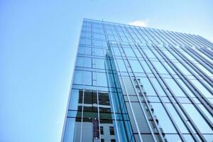 vaso edificio con transparente fachada de el edificio y azul cielo. estructural vaso pared reflejando azul cielo. resumen moderno arquitectura fragmento. contemporáneo arquitectónico antecedentes. foto