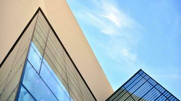 Glass building with transparent facade of the building and blue sky. Structural glass wall reflecting blue sky. Abstract modern architecture fragment. Contemporary architectural background. photo