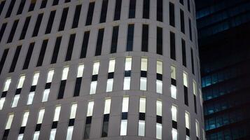 Pattern of office buildings windows illuminated at night. Glass architecture ,corporate building at night - business concept. photo