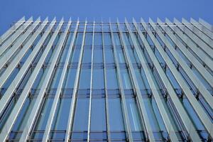 vaso edificio con transparente fachada de el edificio y azul cielo. estructural vaso pared reflejando azul cielo. resumen moderno arquitectura fragmento. contemporáneo arquitectónico antecedentes. foto