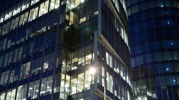 Pattern of office buildings windows illuminated at night. Glass architecture ,corporate building at night - business concept. photo