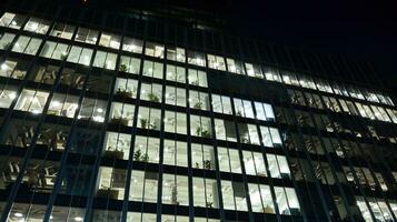 Pattern of office buildings windows illuminated at night. Glass architecture ,corporate building at night - business concept. photo