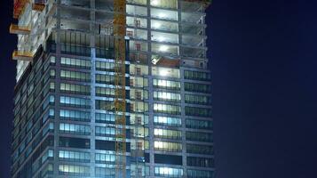 Pattern of office buildings windows illuminated at night. Glass architecture ,corporate building at night - business concept. photo