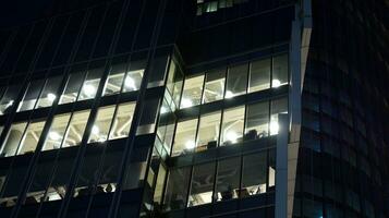 Pattern of office buildings windows illuminated at night. Glass architecture ,corporate building at night - business concept. photo