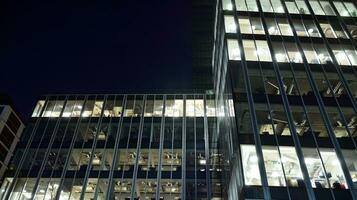 Pattern of office buildings windows illuminated at night. Glass architecture ,corporate building at night - business concept. photo