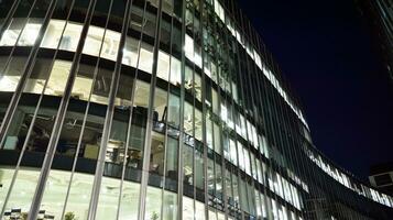 Pattern of office buildings windows illuminated at night. Glass architecture ,corporate building at night - business concept. photo