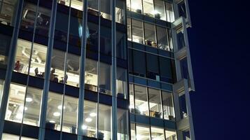 Pattern of office buildings windows illuminated at night. Glass architecture ,corporate building at night - business concept. photo