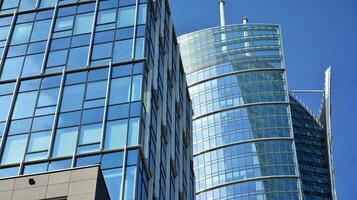 Glass building with transparent facade of the building and blue sky. Structural glass wall reflecting blue sky. Abstract modern architecture fragment. Contemporary architectural background. photo