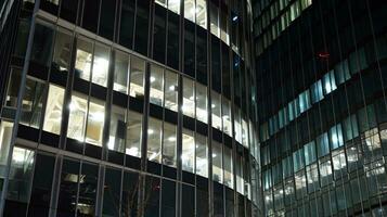 Pattern of office buildings windows illuminated at night. Glass architecture ,corporate building at night - business concept. photo