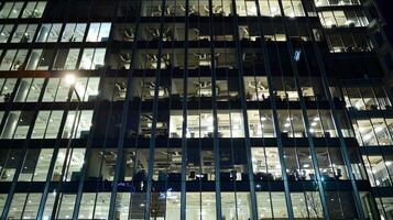 Pattern of office buildings windows illuminated at night. Glass architecture ,corporate building at night - business concept. photo