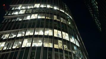 Pattern of office buildings windows illuminated at night. Glass architecture ,corporate building at night - business concept. photo