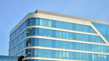 Glass building with transparent facade of the building and blue sky. Structural glass wall reflecting blue sky. Abstract modern architecture fragment. Contemporary architectural background. photo