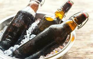 botellas de cerveza en hielo cubitos foto