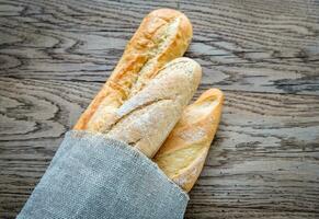 Three baguettes on the wooden background photo