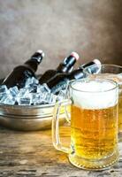 Grilled sausages and mugs of beer photo