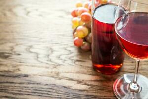 Glass of rose wine with bunch of grape photo