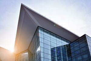 Glass building with transparent facade of the building and blue sky. Structural glass wall reflecting blue sky. Abstract modern architecture fragment. Contemporary architectural background. photo