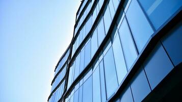 Glass building with transparent facade of the building and blue sky. Structural glass wall reflecting blue sky. Abstract modern architecture fragment. Contemporary architectural background. photo