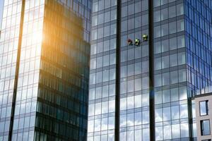 Glass building with transparent facade of the building and blue sky. Structural glass wall reflecting blue sky. Abstract modern architecture fragment. Contemporary architectural background. photo