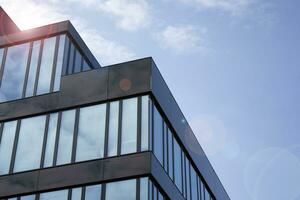 Glass building with transparent facade of the building and blue sky. Structural glass wall reflecting blue sky. Abstract modern architecture fragment. Contemporary architectural background. photo