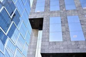 Glass building with transparent facade of the building and blue sky. Structural glass wall reflecting blue sky. Abstract modern architecture fragment. Contemporary architectural background. photo