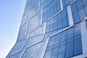 vaso edificio con transparente fachada de el edificio y azul cielo. estructural vaso pared reflejando azul cielo. resumen moderno arquitectura fragmento. contemporáneo arquitectónico antecedentes. foto