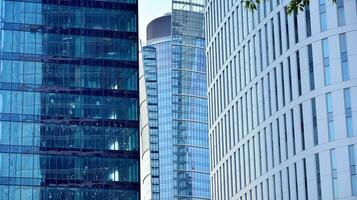 Glass building with transparent facade of the building and blue sky. Structural glass wall reflecting blue sky. Abstract modern architecture fragment. Contemporary architectural background. photo