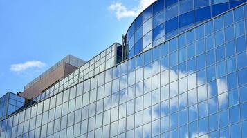 vaso edificio con transparente fachada de el edificio y azul cielo. estructural vaso pared reflejando azul cielo. resumen moderno arquitectura fragmento. contemporáneo arquitectónico antecedentes. foto