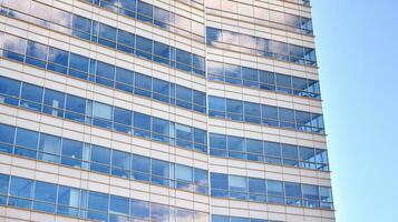 Glass building with transparent facade of the building and blue sky. Structural glass wall reflecting blue sky. Abstract modern architecture fragment. Contemporary architectural background. photo