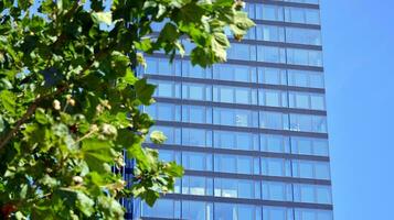 Glass building with transparent facade of the building and blue sky. Structural glass wall reflecting blue sky. Abstract modern architecture fragment. Contemporary architectural background. photo