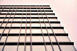 Modern office building with glass facade on a clear sky background. Transparent glass wall of office building. photo