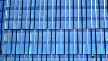 Glass building with transparent facade of the building and blue sky. Structural glass wall reflecting blue sky. Abstract modern architecture fragment. Contemporary architectural background. photo