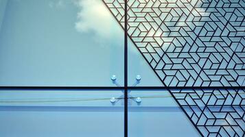 Glass building with transparent facade of the building and blue sky. Structural glass wall reflecting blue sky. Abstract modern architecture fragment. Contemporary architectural background. photo