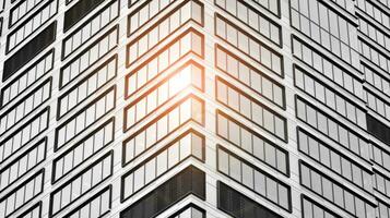 Glass modern building with blue sky background. View and architecture details. Urban abstract - windows of glass office building in  sunlight day. Black and white. photo