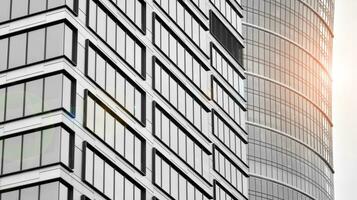 Glass modern building with blue sky background. View and architecture details. Urban abstract - windows of glass office building in  sunlight day. Black and white. photo