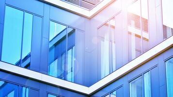 Modern office building with glass facade on a clear sky background. Transparent glass wall of office building. photo