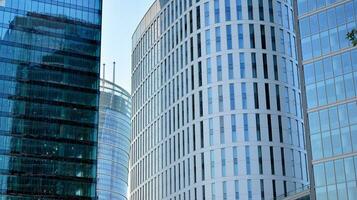 Glass building with transparent facade of the building and blue sky. Structural glass wall reflecting blue sky. Abstract modern architecture fragment. Contemporary architectural background. photo
