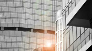 Glass modern building with blue sky background. View and architecture details. Urban abstract - windows of glass office building in  sunlight day. Black and white. photo