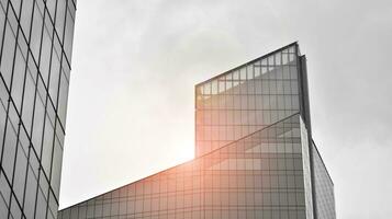 Glass modern building with blue sky background. View and architecture details. Urban abstract - windows of glass office building in  sunlight day. Black and white. photo