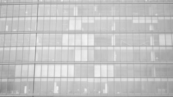 Glass modern building with blue sky background. View and architecture details. Urban abstract - windows of glass office building in  sunlight day. Black and white. photo