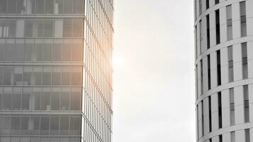 Glass modern building with blue sky background. View and architecture details. Urban abstract - windows of glass office building in  sunlight day. Black and white. photo