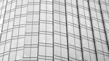 vaso moderno edificio con azul cielo antecedentes. ver y arquitectura detalles. urbano resumen - ventanas de vaso oficina edificio en luz de sol día. negro y blanco. foto